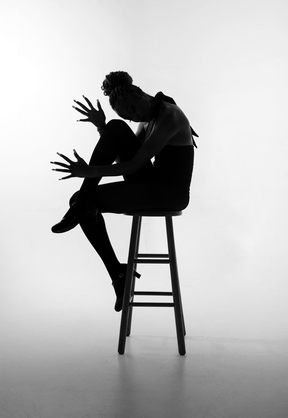 Silhouette, seated on a stool